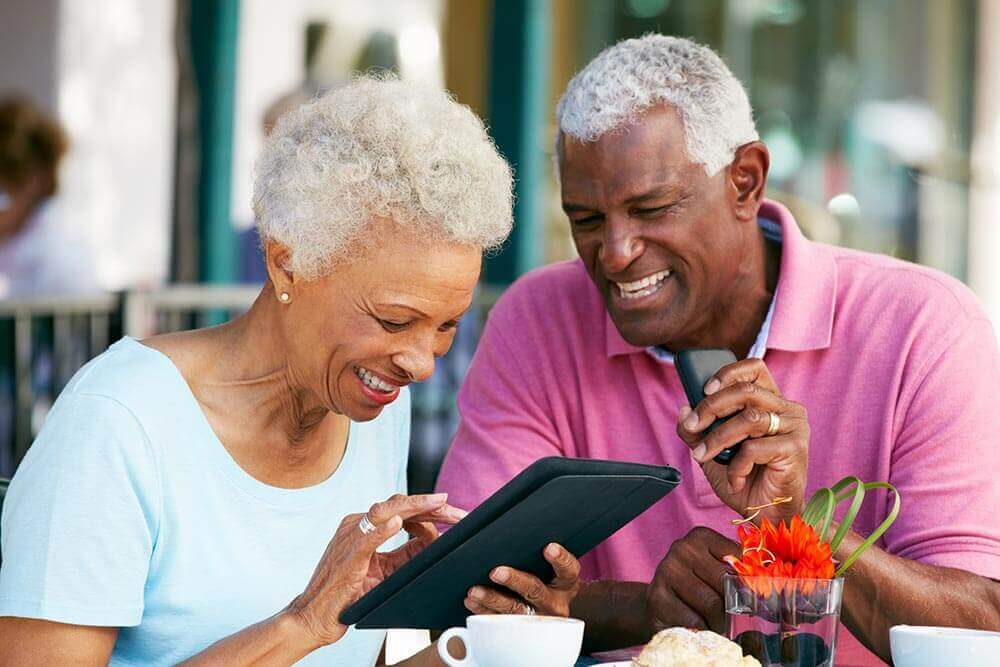 Couple Smiling While Looking at a Tablet Computer